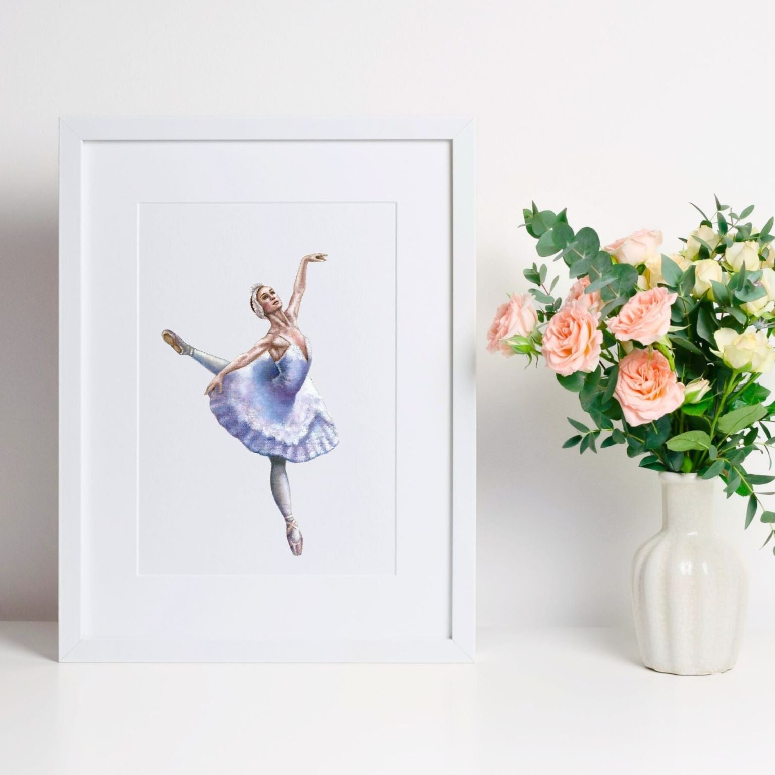 Framed print of a ballerina playing Odette in the Swan Lake ballet, en pointe in a white tutu with her arms outstretched.